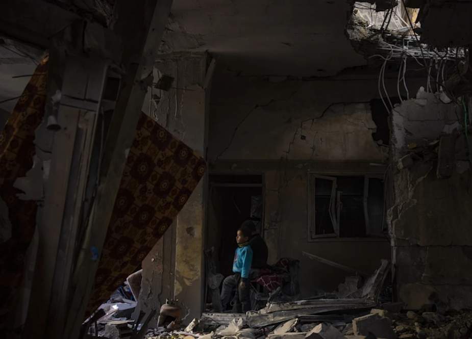 A Palestinian child looks at the damage to his family’s house after an Israeli strike in Rafah