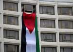 Demonstrators hang a Palestinian flag out a window at the Washington Hilton Hotel, at the White House Correspondents
