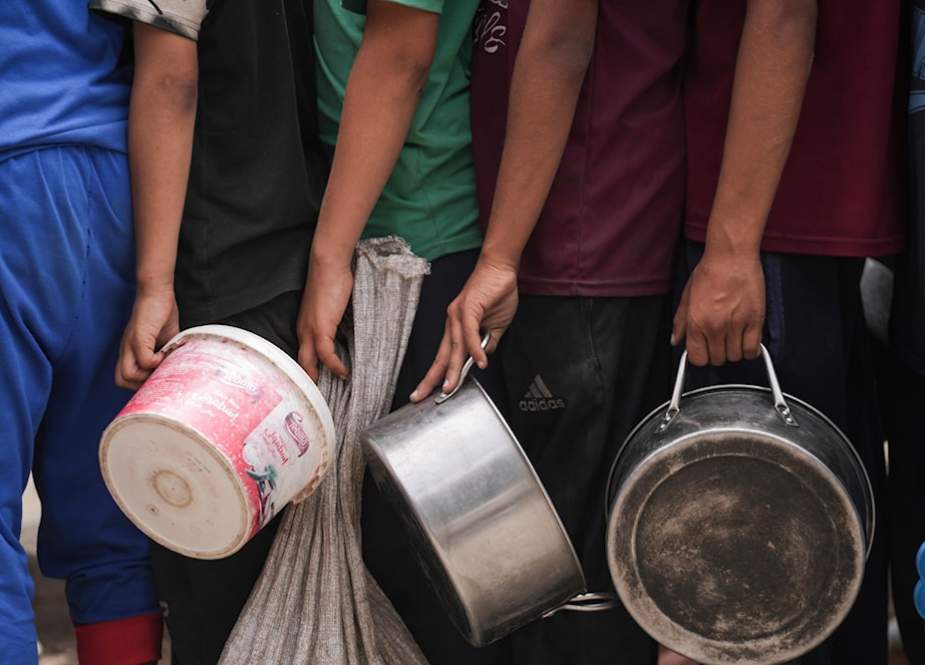Palestinians line up for food distribution in Deir al-Balah, Gaza