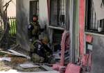 Israeli occupation forces examine the site hit by a rocket fired from Lebanon, in Kiryat Shmona