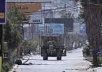 An Israeli army bulldozer invades a street during a raid in the West Bank city of Jenin