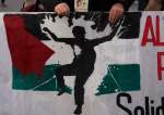 A protester march carrying a banner showing the Palestinian flag, in support of Palestinians in Madrid, Spain