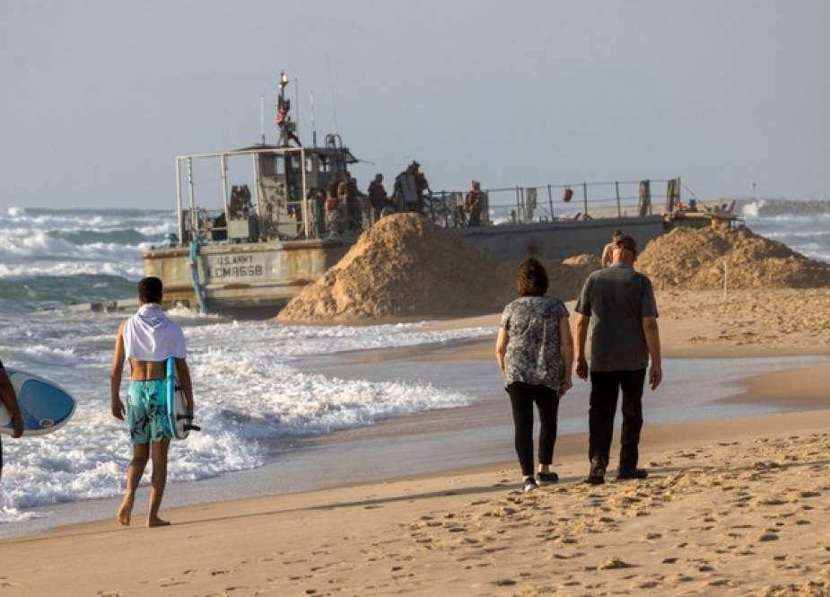 Israelis walk near a US Army vessel at that ran aground at a beach in the coastal city of Ashdod