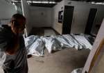 A person stands near the bodies of Palestinians killed in an Israeli strike